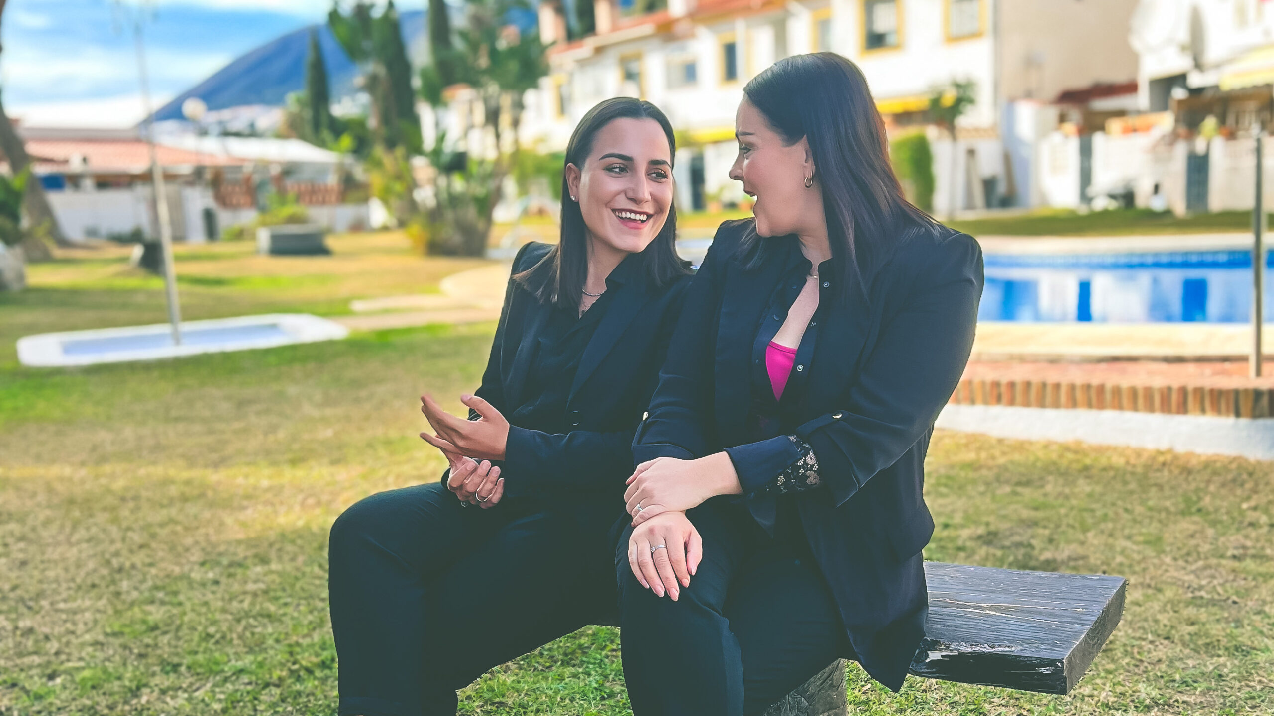 Laura and Raja from La Raya Spanish Properties siting in a Marbella garden discussing real estate in Marbella